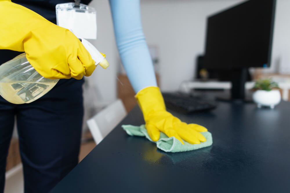 a professional cleaner wiping an office table